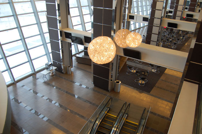 Club bar at Cowboys Stadium: a tiled bar front, a dark tile floor, and a glass wall behind