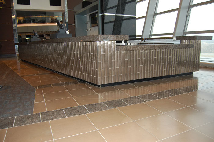 Bar front at Cowboys Stadium faced in small mosaic tile, a glossy dark floor in front