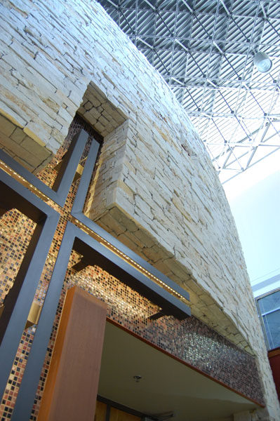 Cross cut into a stone-clad wall at The Hills Church, seen from below