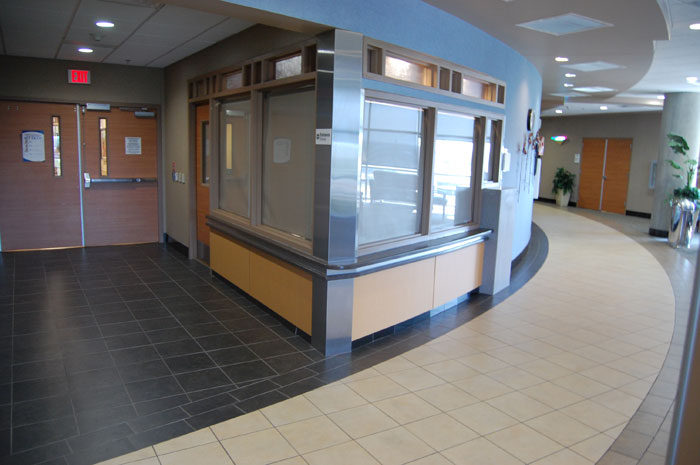 Curved corridor at John Peter Smith Hospital with a dark tile band following the curve