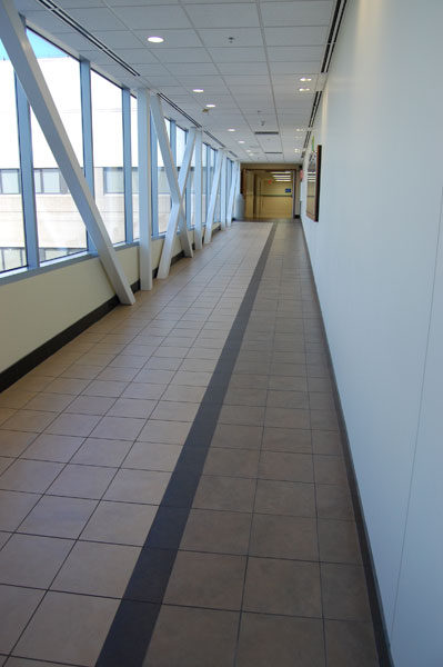 Glazed walkway at John Peter Smith Hospital, a dark tile stripe down a light floor